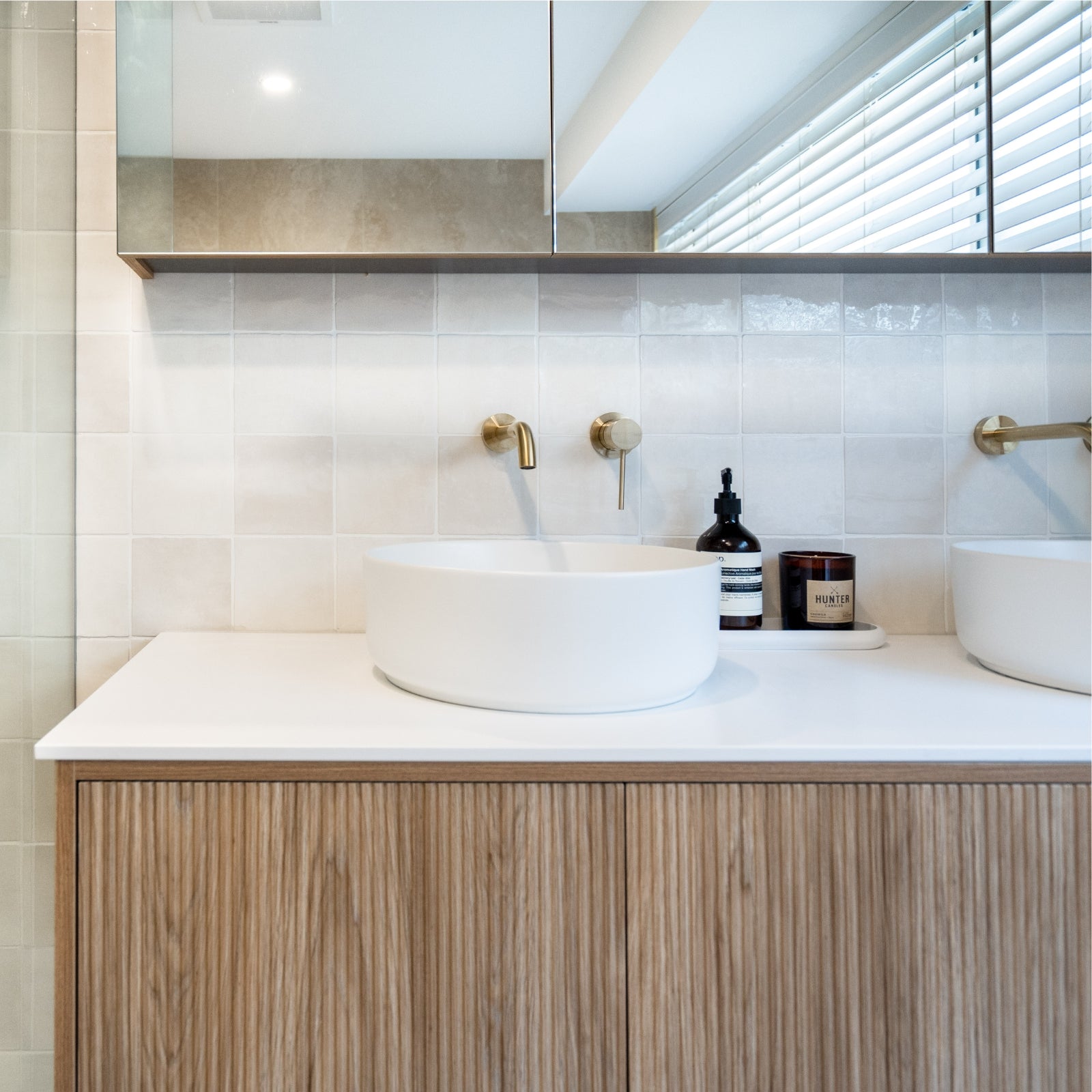 Bathroom vanity with white countertop, round sink, and wooden cabinets. Snow White Ella Zellige Tile 100 x 100 x 10mm Spanish Ceramic | The Blue Space