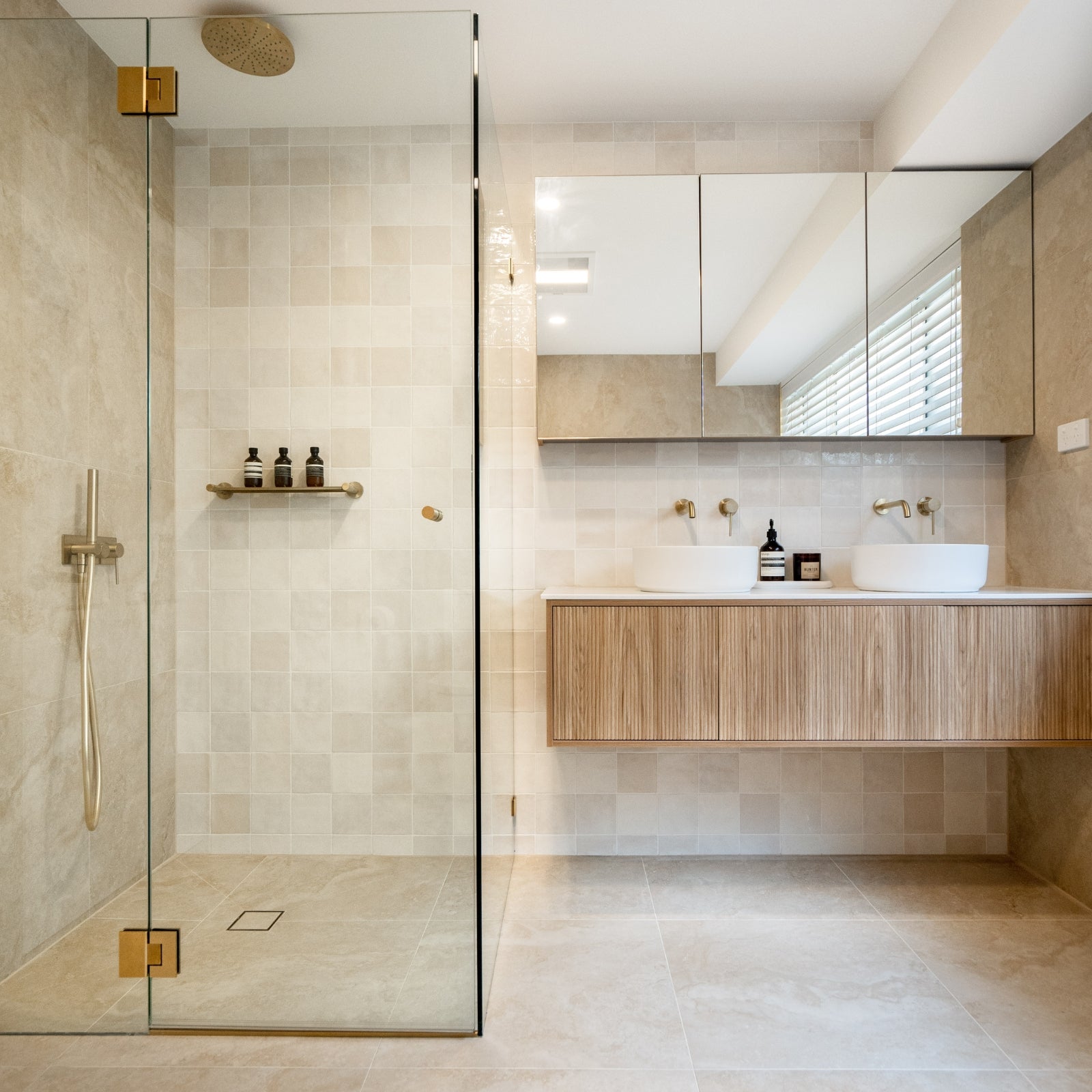 Modern bathroom with glass shower enclosure and wooden vanity.