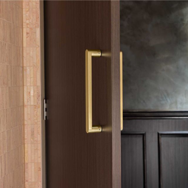 Zanda Duke 330mm Pull Handle in Satin Gold on walnut door with terracotta tiles