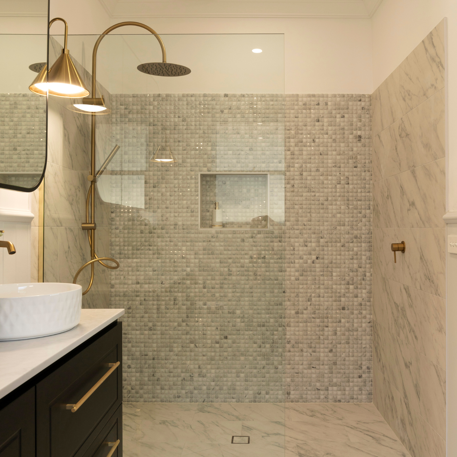 Caroma Brushed Brass tapware and shower in marble tiled bathroom