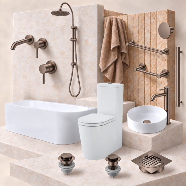 A coordinated bathroom fixture set displayed on a beige stone-look platform: a white rectangular bathtub, white toilet, white vessel sink, wall-mounted shower system, towel, wall bars, faucet, drain, and two drain assemblies. The fixtures have a warm brushed metallic finish, and the background is a matching beige tiled wall.