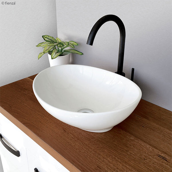 Fienza Paola Above Counter Basin with a black basin mixer on a wooden benchtop vanity