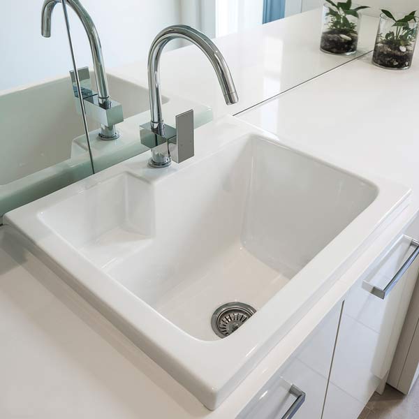 Seima Eva Ceramic Laundry Sink on a white benchtop and a chrome sink mixer